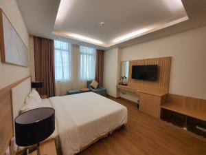 a hotel room with a bed and a flat screen tv at Muong Thanh Vung Tau Hotel in Vung Tau
