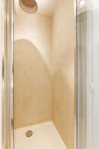 een douche met een glazen deur in de badkamer bij Comfortion Zaira - Suite de luxe avec vue sue la Défense in Puteaux