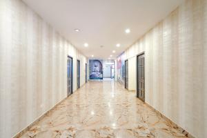 a hallway of a building with marble floors and walls at FabHotel Perfect Stays in Chennai