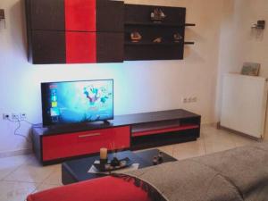 een woonkamer met een flatscreen-tv aan de muur bij Το σπίτι της Περσεφόνης in Athene