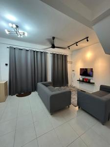 ein Wohnzimmer mit 2 Sofas und einem Flachbild-TV in der Unterkunft HStay Ipoh in Ipoh
