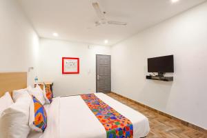 a bedroom with a bed and a flat screen tv at FabHotel Perfect Stays in Chennai