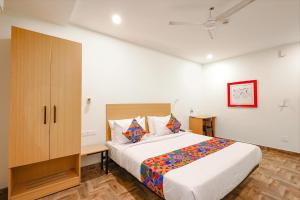 een slaapkamer met een groot bed en een kast bij FabHotel Perfect Stays in Chennai