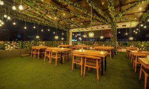 una sala da pranzo con tavoli e sedie in legno di Treebo Trend Park Palace a Guwahati