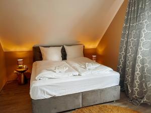ein Bett mit weißen Laken und Kissen in einem Zimmer in der Unterkunft Apt Prinz Maximilian - Zentrum - Zimmerprinzen in Oldenburg