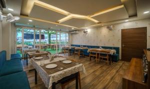 um restaurante com mesas e cadeiras num quarto em Treebo Trend Park Palace em Guwahati