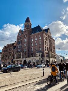 un groupe de personnes faisant du vélo devant un bâtiment dans l'établissement Hotel TwentySeven - Small Luxury Hotels of the World, à Amsterdam
