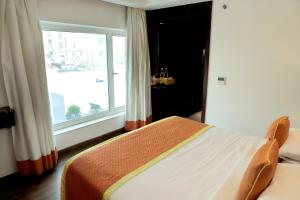 a bedroom with a bed and a large window at Zone By The Park , Bani Park Jaipur in Jaipur
