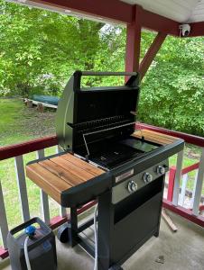 a grill sitting on a porch with a table at Le chalet du bout du monde, en bord de rivière ! in Grez-sur-Loing