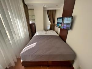 - une chambre avec un lit et une télévision murale à écran plat dans l'établissement Genoa Port Hotel, à Istanbul