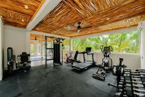 a gym with several exercise equipment in a room at Samawa Living in Paje