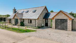 a brick house with a garage and a driveway at Canaan in Worth Matravers