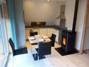 a dining room with a table and a stove at COUCOU in La Forge