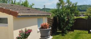 a garden with a flower pot next to a house at Au fil de l'Orge in Saint-Chéron