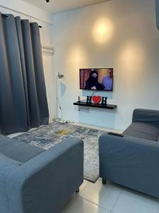 ein Wohnzimmer mit einem Sofa und einem Flachbild-TV in der Unterkunft HStay Ipoh in Ipoh