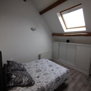 a bedroom with a bed and a window at Au fil de l'Orge in Saint-Chéron