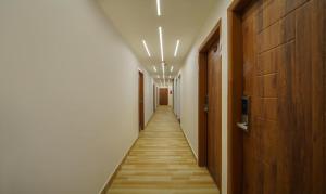 einen Flur mit einem langen Korridor mit Holzböden und Leuchten in der Unterkunft Treebo Trend Park Palace in Guwahati
