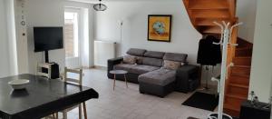 a living room with a couch and a table at Au fil de l'Orge in Saint-Chéron