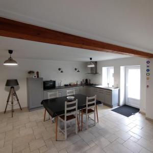 a kitchen with a table and chairs in a room at Au fil de l'Orge in Saint-Chéron