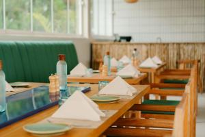 a dining room with wooden tables and chairs with napkins at Samawa Living in Paje