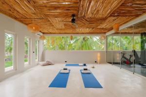 a yoga room with blue mats on the floor at Samawa Living in Paje