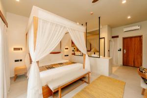 a bedroom with a bed with a canopy at Samawa Living in Paje
