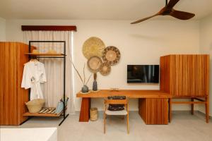 a room with a desk with a television and a fan at Samawa Living in Paje