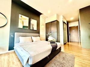 1 dormitorio con 1 cama grande y pared negra en Ceylonz Suites KL City by One39KL en Kuala Lumpur