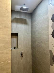 a bathroom with a shower with a tile wall at Ceylonz Suites KL City by One39KL in Kuala Lumpur