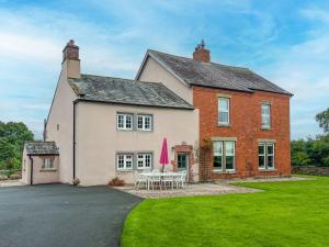 a large house with tables and chairs in the yard at High House Cottage Southwaite in Southwaite
