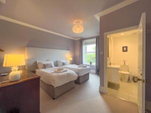 a bedroom with a large bed and a bathroom at High House Cottage Southwaite in Southwaite