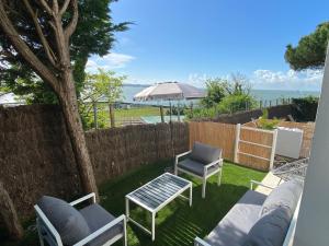 a patio with chairs and a table and an umbrella at Villa face mer in Royan