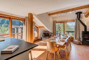 uma sala de jantar e sala de estar com mesa e cadeiras em Les Melées Apartments - Alpes Travel - Argentiere em Chamonix-Mont-Blanc