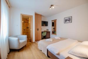 una camera d'albergo con due letti e una sedia di Hotel Zlatni bor a Žabljak Altre 37 foto