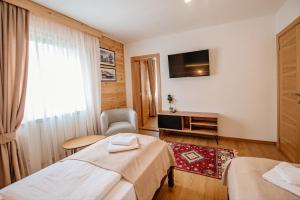 ein Hotelzimmer mit 2 Betten und einem TV in der Unterkunft Hotel Zlatni bor in Žabljak