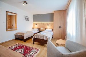 um quarto de hotel com duas camas e um sofá em Hotel Zlatni bor em Žabljak
