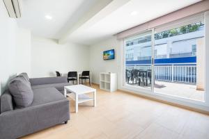 ein Wohnzimmer mit einem Sofa und einem großen Fenster in der Unterkunft Apartamentos La Rosita Old Town B-21 in Benidorm