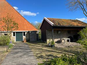 una casa de ladrillo con techo naranja y entrada en Gastenverblijf Bonga Stee, en Roodhuis