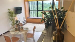 a living room with a table and chairs and a window at Kami Tami Japandi Poolview in Putrajaya
