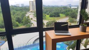 a laptop sitting on a desk in front of a window at Kami Tami Japandi Poolview in Putrajaya