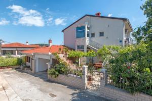 a house with a fence in front of it at Apartman Oliva in Pula
