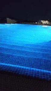 ein blauer Pool mit blauen Fliesen auf dem Boden in der Unterkunft Hotel Abi - Baile Felix in Baile Felix