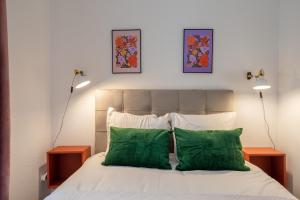 - une chambre avec un lit et 2 oreillers verts dans l'établissement Travel Homes - Niffel 1 - Un havre de paix près du Parc, à Mulhouse