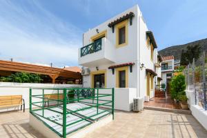 Biały dom z zieloną poręczą na patio w obiekcie Elen-Mari w mieście Hersonissos