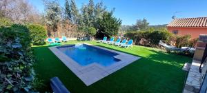 a backyard with a swimming pool and chairs on the grass at Bravaholidays-602-Lloret Park 2 in Vidreres