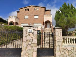 a house with a gate and a fence at Bravaholidays-602-Lloret Park 2 in Vidreres