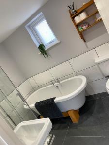 a bathroom with a bath tub and a sink at Tregue Cottage in Camelford