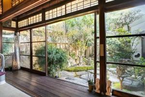 Habitación con ventana grande con vistas al jardín. en Kominka Mitsuhama Ryokan en Matsuyama