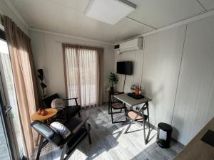 uma pequena sala de estar com mesa e cadeiras em Tiny House QiriH em Zierikzee