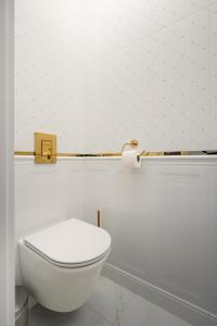 W łazience znajduje się biała toaleta i papier toaletowy. w obiekcie Golden Villa Saska Kępa w Warszawie